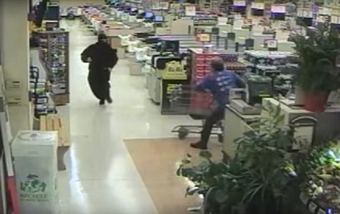 A robbery suspect is shown on a security camera being chased out of a Burke grocery store.