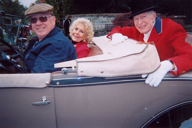 Seated in the rumble seat of a 1931 Model A Ford Roadster is Austin H. Kiplinger, the Grand Marshal of the 2015 Potomac Day Parade. Kiplinger, 97, is wearing Potomac Hunt formal hunting attire. He is a former hunt committee chairman and a member since 1961. Bonnie Nicholson, and car owner/driver, Chuck McDonald, are seated in front.
