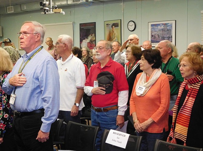 Program attendees sing the national anthem together.