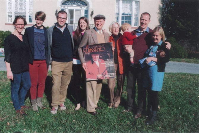 The family of the late Austin H. “Kip” Kiplinger gathered at the Kiplinger River Road home, “Montevideo,” for the annual Potomac Hunt Thanksgiving Day meet. His son, Knight Kiplinger, holds one of  several enlarged photos that were shown commemorating the hunting days of his father. From left are: Heidi Stucker, Sutton Kiplinger, Dave Steadman, Daphne Kiplinger, Knight Kiplinger, his wife, Ann, their son Bringham holding year-old Nate, and Bringham’s wife, Eliza, with 8-day-old Callan Ford Kiplinger.
