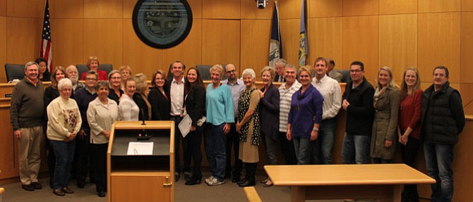 Mario (white shirt) and Andrea (holding certificate) Weber, surrounded by friends and members of the Cultivating Community Initiative, the volunteer group that produces the Good Neighbor Award.
