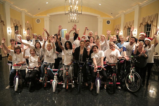 Volunteers gather for a group photo at the fourth annual Visit Alexandria Bows, Baskets and Bikes charity event Nov. 19 at Christ Church.
