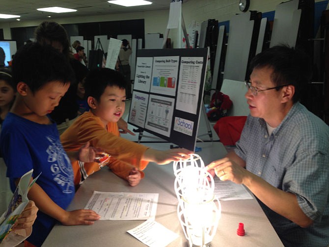 Forestville Parent and PTA co-vice president of Curriculum Niu‐Niu Chen of Great Falls volunteers at the event to help children observe and calculate the energy costs of three different kinds of bulbs. 
