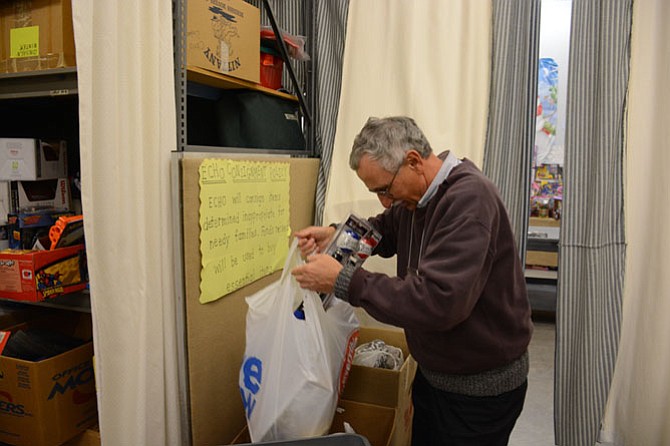 Volunteer Tom Palumbo of Kingstowne processes a new donation at the warehouse for Ecumenical Community Helping Others.