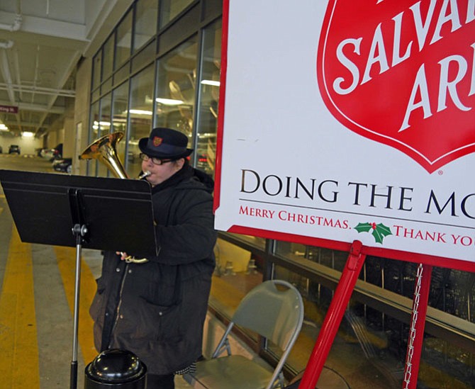 In three hours Emily Lawton will be at Dulles Airport waiting for a plane to take her back to England. For the last four years she has come to Alexandria to volunteer with the Salvation Army for several weeks playing her alto horn beside the “big red donation kettle.”
