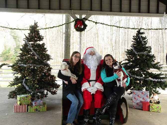 Katelynn Bradley, of Springfield, with pet Layla and Amanda Temenak, of Alexandria, with pet Romeo, flank Santa at the pavilion in Lake Accotink Park in Springfield.
