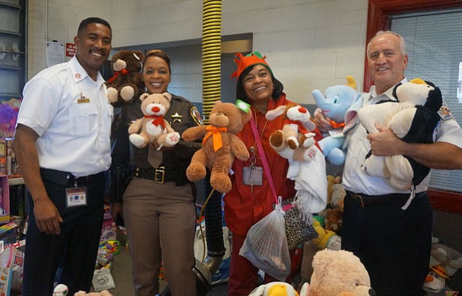 Firefighters and Friends founder Capt. Willie Bailey, left, is joined by Charise Mitchell, Annie Dawkins and Fairfax County Fire Chief Richard Bowers at the Dec. 15 toy distribution day at Penn Daw Fire Station 11.
