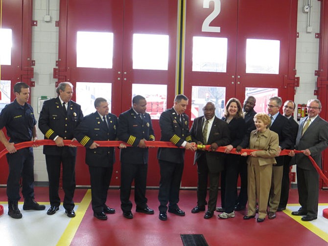 Firefighters and City Council unbuckle a hose, the Fire Station equivalent to a ribbon cutting.

