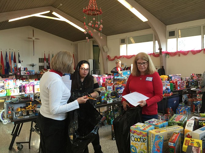 Koinonia volunteers Elaine Sullivan (left) and Kay Perkins (right) help client Stefanie S. (center) shop for gifts at the Christmas Wishes Program held at St. John’s Lutheran Church in Franconia. 