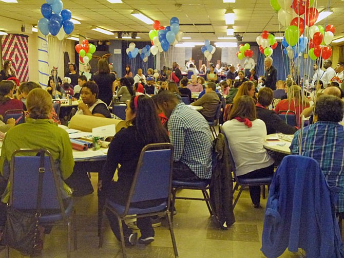 About 150 volunteers gather around tables set up with gift wrap at the annual OAR gift wrapping event where 1,200 presents will be wrapped, three each for about 375 children of prisoners in Arlington County or the cities of Alexandria and Falls Church.
