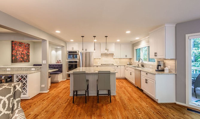 The “open” floorplan introduced to the Millette's Reston home by Foster Remodeling eliminates walls yet increases storage capacity. By re-routing ceiling flush HVAC, the contractor introduced cabinets 30 percent taller than their predecessors. The food preparation island accommodates a full array of cookware and crockery in custom-designed cubbies.
