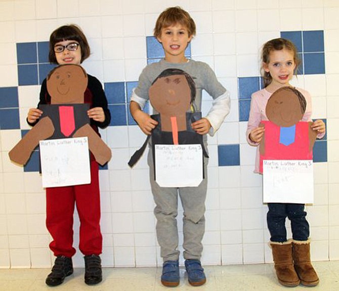 Barbara Lewis’ kindergarten class at Churchill Road made cut-paper portraits of Martin Luther King, Jr., and shared a fact about his life.  Pictured are Emily Foley, Alvaro Escobero-Marco and Emma Kry.
