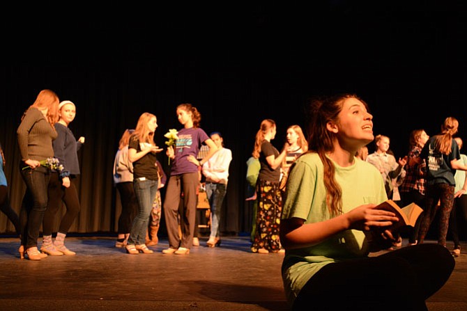 Belle, played by senior Kirsten Chase (right), rehearses for “Beauty and the Beast” with the Village cast behind her.