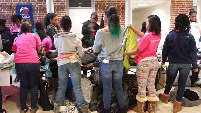 Middle and high school students from Northern Virginia and Maryland sort clothes by appropriate category. 
