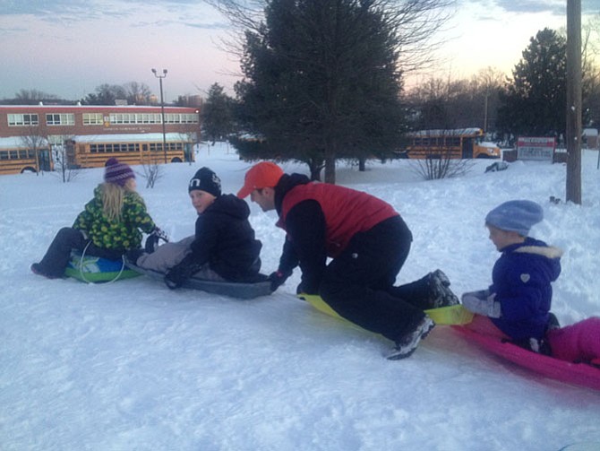 Herndon resident and Herndon HS graduate Jeff Sevila prepares for a slide ride by Herndon Elementary School. Fairfax County Public Schools and offices were closed Monday and Tuesday, Jan. 25 and 26. 
