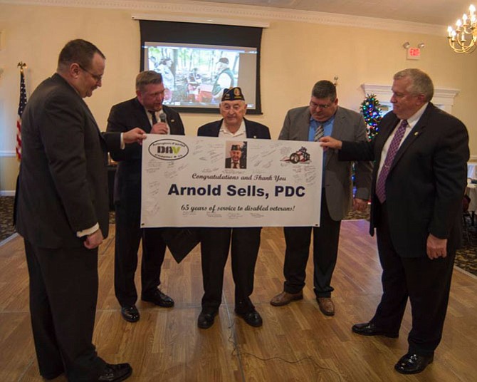 Members of area Disabled American Veterans (DAV) chapters congratulate Arnold Sells for his 65 years of service.
