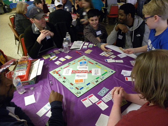 The players at this table during second round of the ninth Monopoly tournament wheel and deal to buy and sell property.
