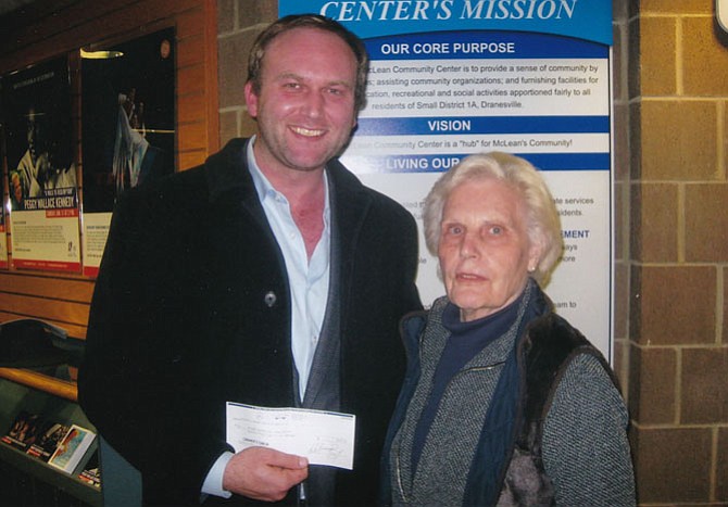 Carole Herrick, chair of McLean & Great Falls Celebrate Virginia handing residual funds to Paul Kohlenberger, president of the McLean Historical Society.
