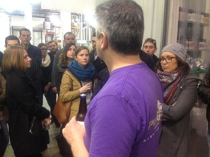 Visitors to Port City Brewing Company listen to a tour guide explain the basic brewing process. 