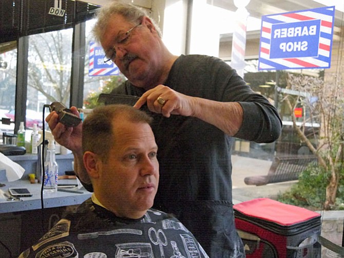 Brent McBurney follows Murphy into the barber chair. He has come to get a trim before his upcoming business trip to two human rights conferences in Thailand and Australia.