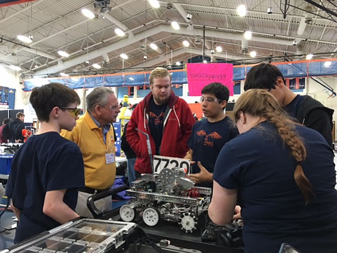 <C://>Hawks team members discuss their robot with an FTC Judge who has come to visit their pit area.  
