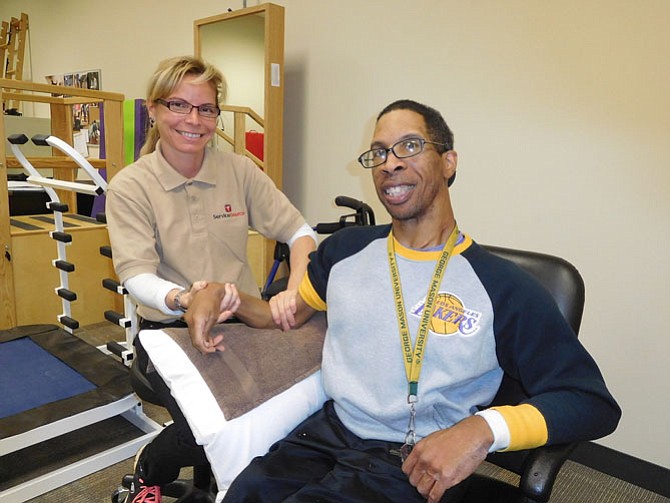 Physical therapy assistant Celine Tourpe hopes to improve Ronald Lambert’s range of motion.
