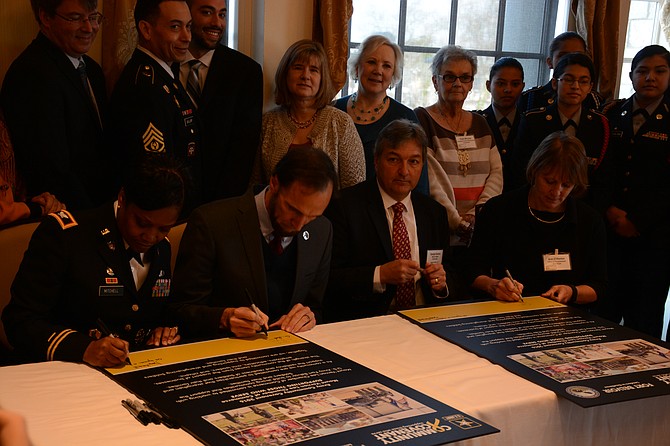 From left, Fort Belvoir Garrison Commander Col. Michelle Mitchell, Supervisor Dan Storck (D-Mount Vernon), George Ksenics of Belvoir Federal Credit Union and Ann O’Hanlon from the office of U.S. Rep. Don Beyer (D-8) sign the renewed Community Covenant between Fort Belvoir and the Mount Vernon area.