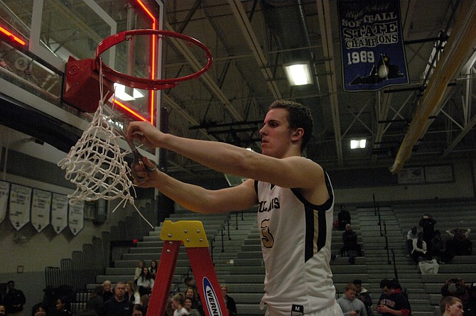 Westfield senior Tyler Scanlon cuts off a piece of the net after the Bulldogs won the Conference 5 championship on Friday.