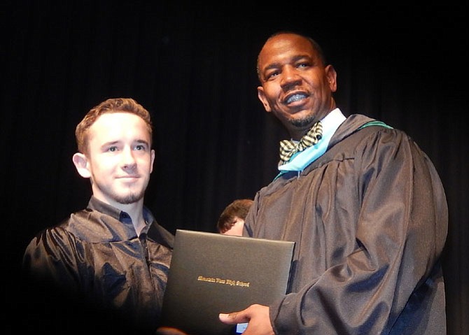 Student speaker Sergei Kuehne receives his diploma from Principal Gary Morris.
