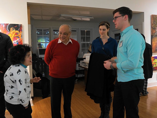 Exhibit curator Joshua Oliveira, right, talks with Yasmine Iskander about her work as Magdi Iskander and Tristann Brown look on.