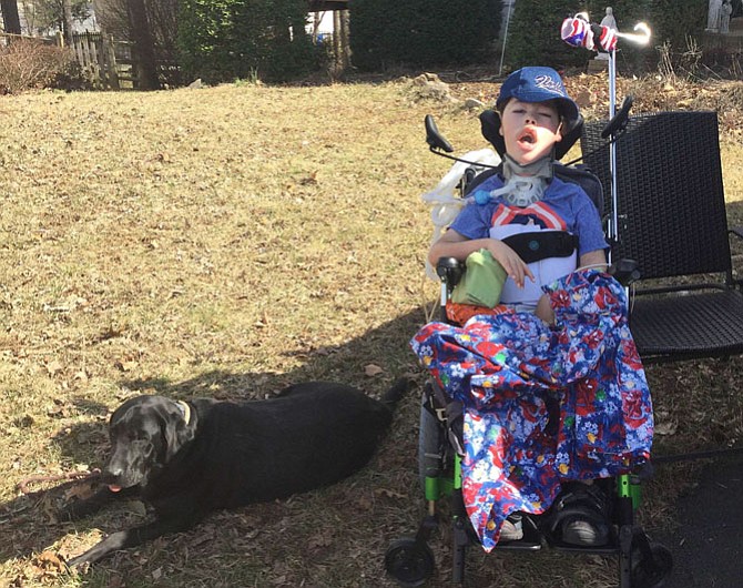 Liam Bruen outside, relaxing with his dog, Patch.
