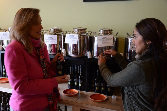 Patty Damiani of the Fort Hunt area (left) and Ransha Ahmed of Alexandria sample and discuss some of the flavored balsamic vinaigrettes at EVOO at Mamma’s Market.