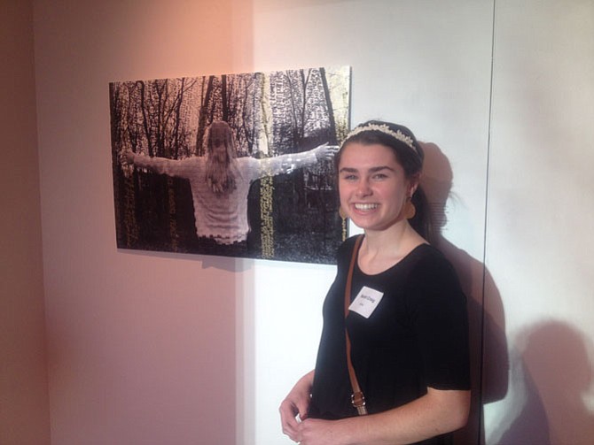 Sarah Craig, a senior at Oakton High School by her art piece on display at Greater Reston Arts Center (GRACE). Her mixed media piece includes commentary by local neighbors. 
