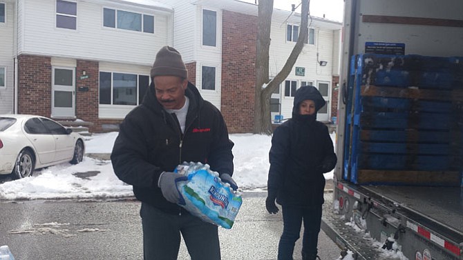 John Lawrence and Jenna Adams, members of Alfred Street Baptist Church in Alexandria, help unload water at an apartment complex in Flint.
