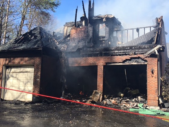 Firefighters encounter smoke and fire from the garage and attic upon arrival to the house on Windsong Drive in Oakton on Tuesday, March 30.
