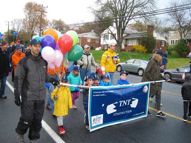 The little league team sponsored by TNT Construction heads down the parade route.
