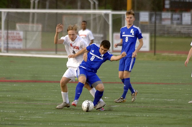 South Lakes senior Antonio Martinez (8) and Madison senior Gunnar Almquist battle for the ball during Monday’s match in Vienna.