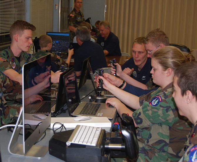 Civil Air Patrol (CAP) Senior Members and Cadets  from the Prince William and Burke Composite Squadrons concentrate at the controls of their flight simulators.    