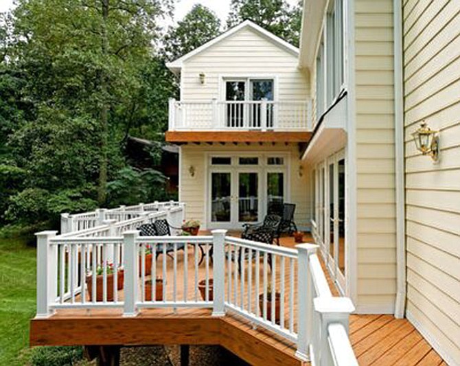 Doors, such as a quad-panel gliding door or full-swing French door, create a large opening for joining interior and exterior spaces, a feature of this McLean deck by Michael Winn of Winn Design + Build. 
