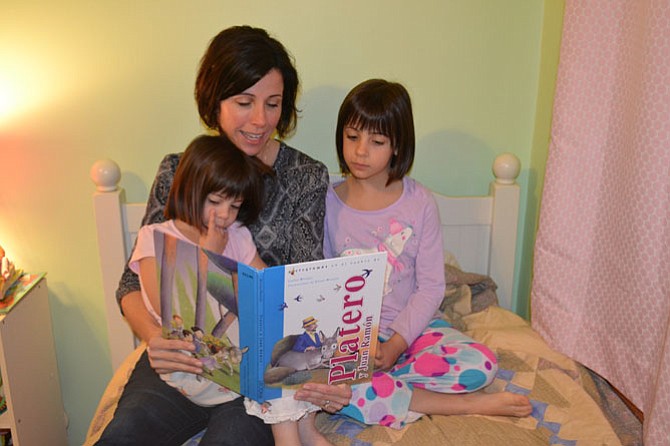 Martha Davis reads a book written in Spanish with her daughters, 6-year-old Alice (right) and 4-year old Jane. Alice is in a Spanish immersion program at Mt. Vernon Community School in Alexandria.  
