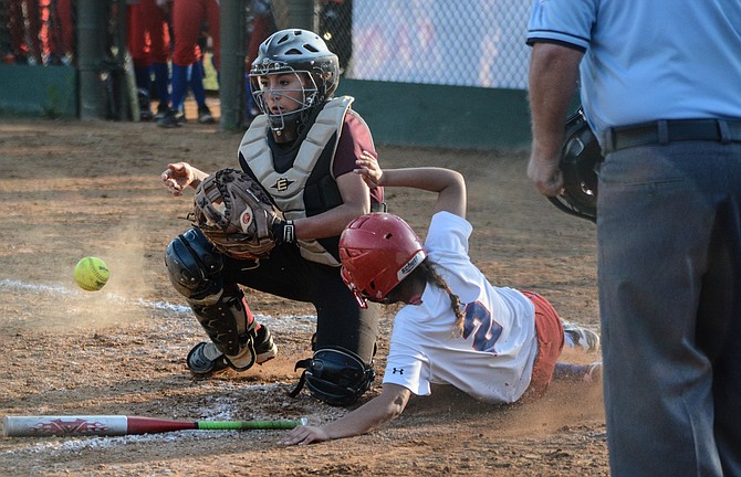 T.C. Williams senior Calla Zane slides past Mount Vernon catcher Sophia Castillo to score what proved to be the winning run in the bottom of the third inning during their Conference 7 tournament quarterfinal game on Monday.