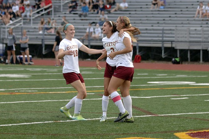 Oakton players (from left) Caitlin Violet, Alex Marquis and Alana Moore celebrate during the Cougars’ 6A North quarterfinal game against Madison on May 26.