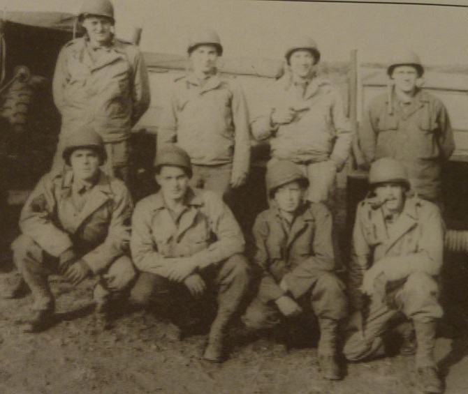 Alexandria resident Bill McNamara, standing second from left, and his Stars and Stripes team on Omaha Beach in Normandy three days after the D-Day invasion in June 1944.
