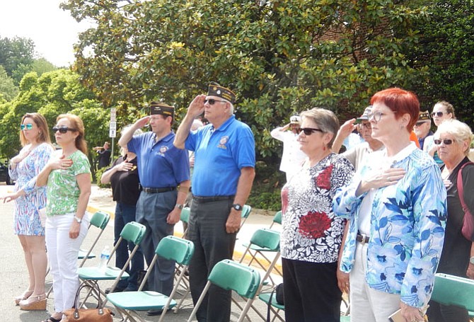 Residents and veterans stand at attention while bugler Hank Roeder plays “Taps” in the background.
