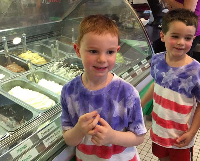 Friends look over the ice cream case at Pazzo To Go Gelato.
