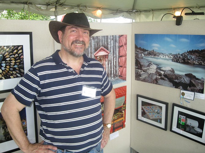 Dean Souleles shows off his photography during the Great Falls Art Fest on the Green last weekend.
