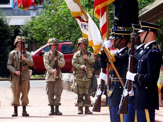 Members of the U.S. Army Old Color Guard, led by Sergeant James Porterfield, present the colors with the salute of D-Day reenactors.