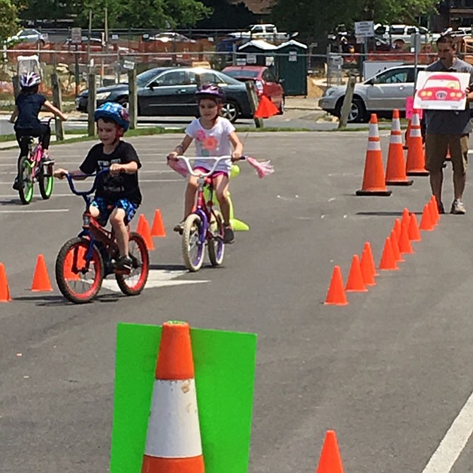 Two children practice their biking skills around the obstacle course set up by Vienna Parks and Recreation and monitored by Vienna police officers and volunteers.
