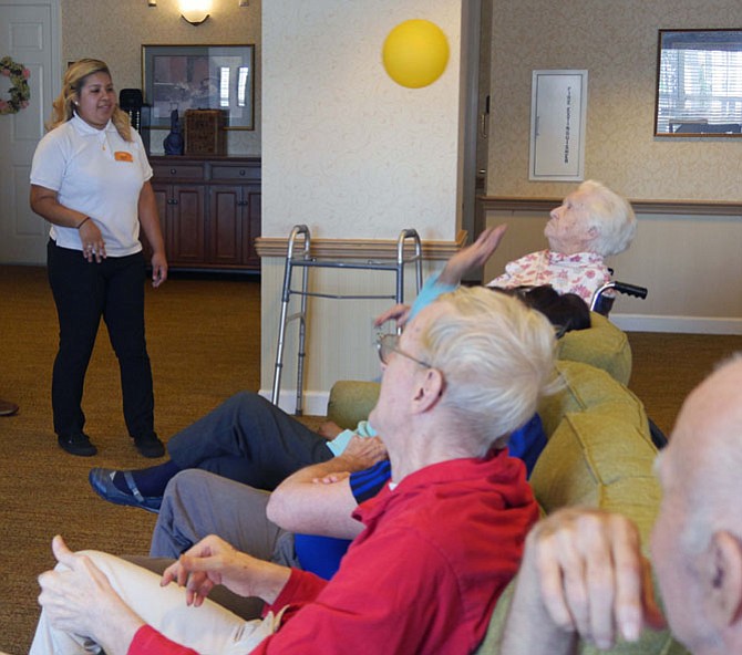 Jenny Bonilla tosses the balloon back and forth to residents in one of the favorite afternoon activities in Reminiscence at Sunrise of Alexandria. There are 33-34 residents in the Memory Care neighborhood for late stage dementia.