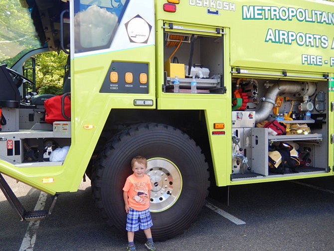 Little boy, big truck: Cyrus Dudik, 3-1/2, stands in front of a Metropolitan Washington Airports Authority fire-and-rescue vehicle.
